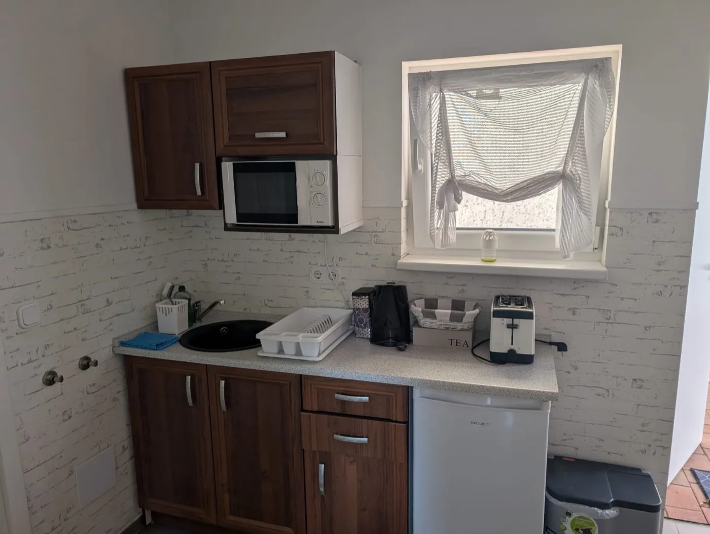 Küche der Wohnung Birke in Erkner mit Mikrowelle, Kühlschrank, Toaster und Wasserkocher